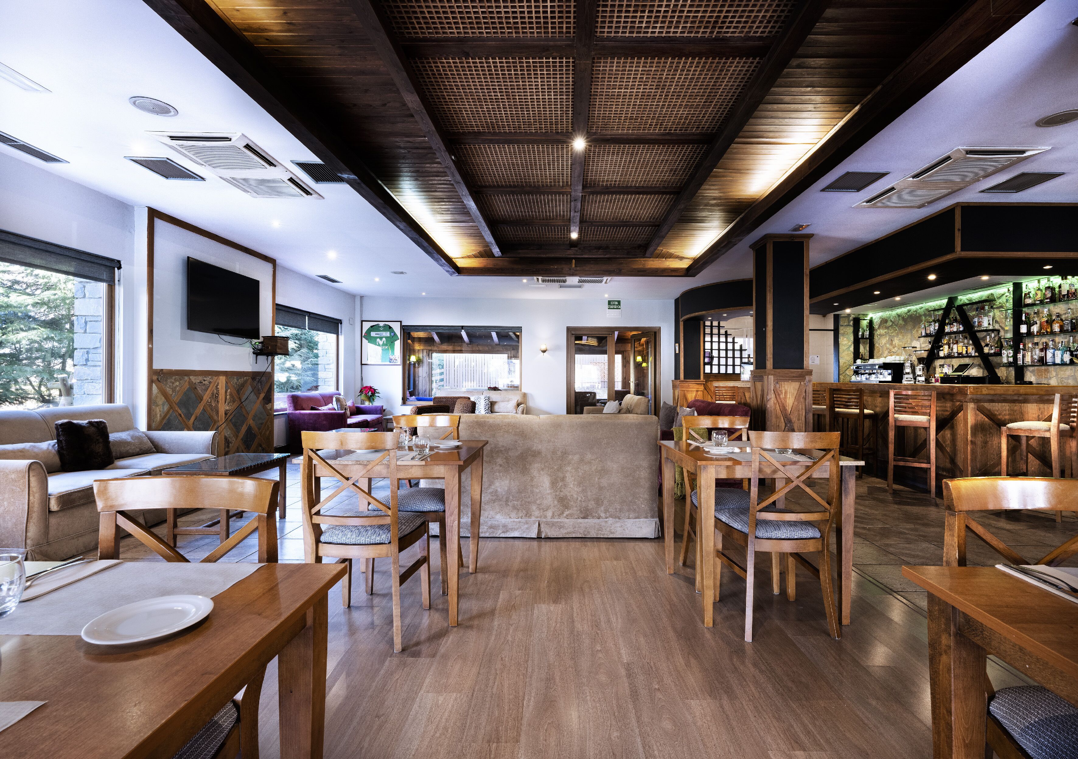 A modern interior with wooden furniture, a bar area, and a seating area with a view.