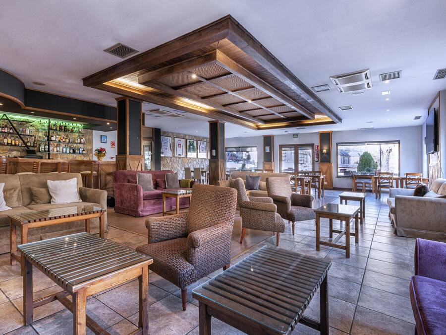 A spacious lobby with a bar area, seating arrangements, and large windows providing views.