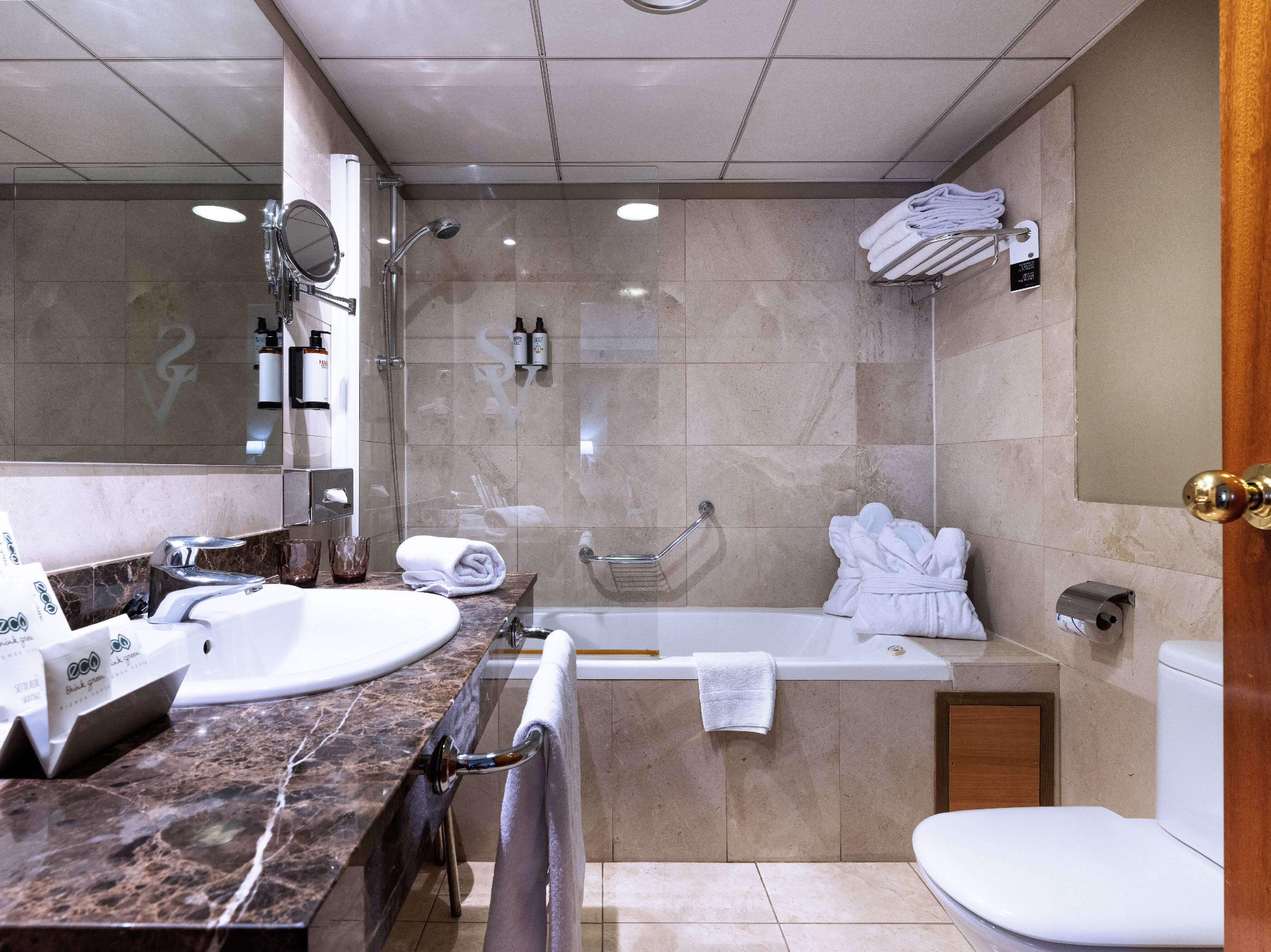 A modern bathroom with a bathtub, toilet, and sink.