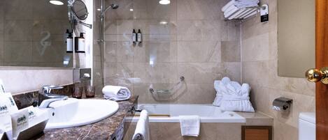 A modern bathroom with a bathtub, toilet, and sink.