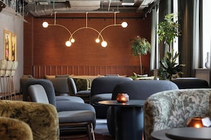 A modern interior with seating arrangements, a hanging light fixture, and a potted plant. - The Cloud One Frankfurt-Metropolitan (Frankfurt)