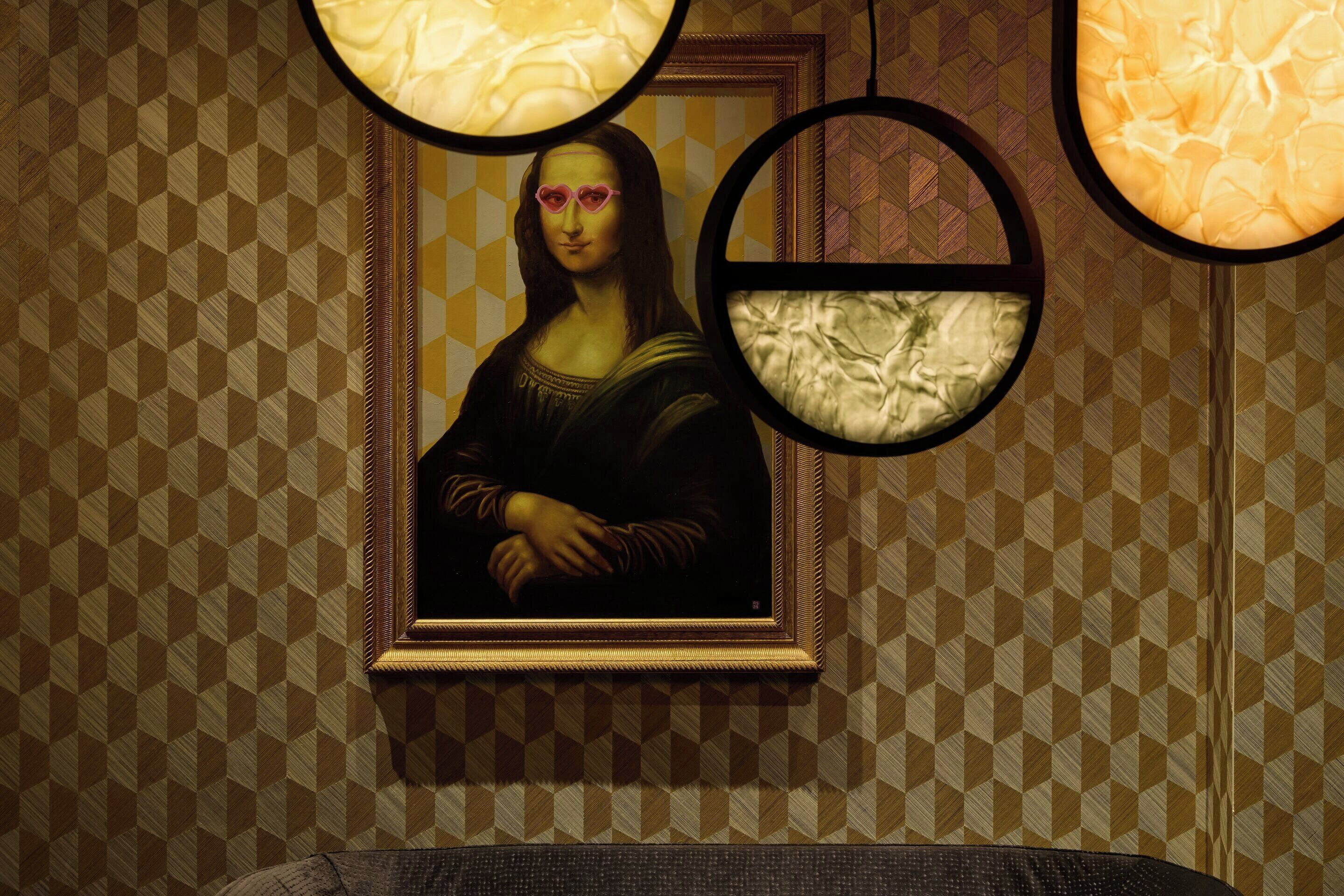 A framed artwork on a patterned wall.