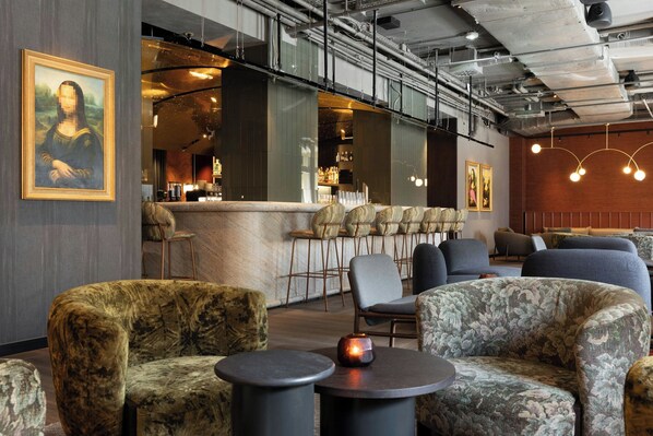 A modern interior with seating, a bar area, and artwork on the walls. - The Cloud One Frankfurt-Metropolitan (Frankfurt)