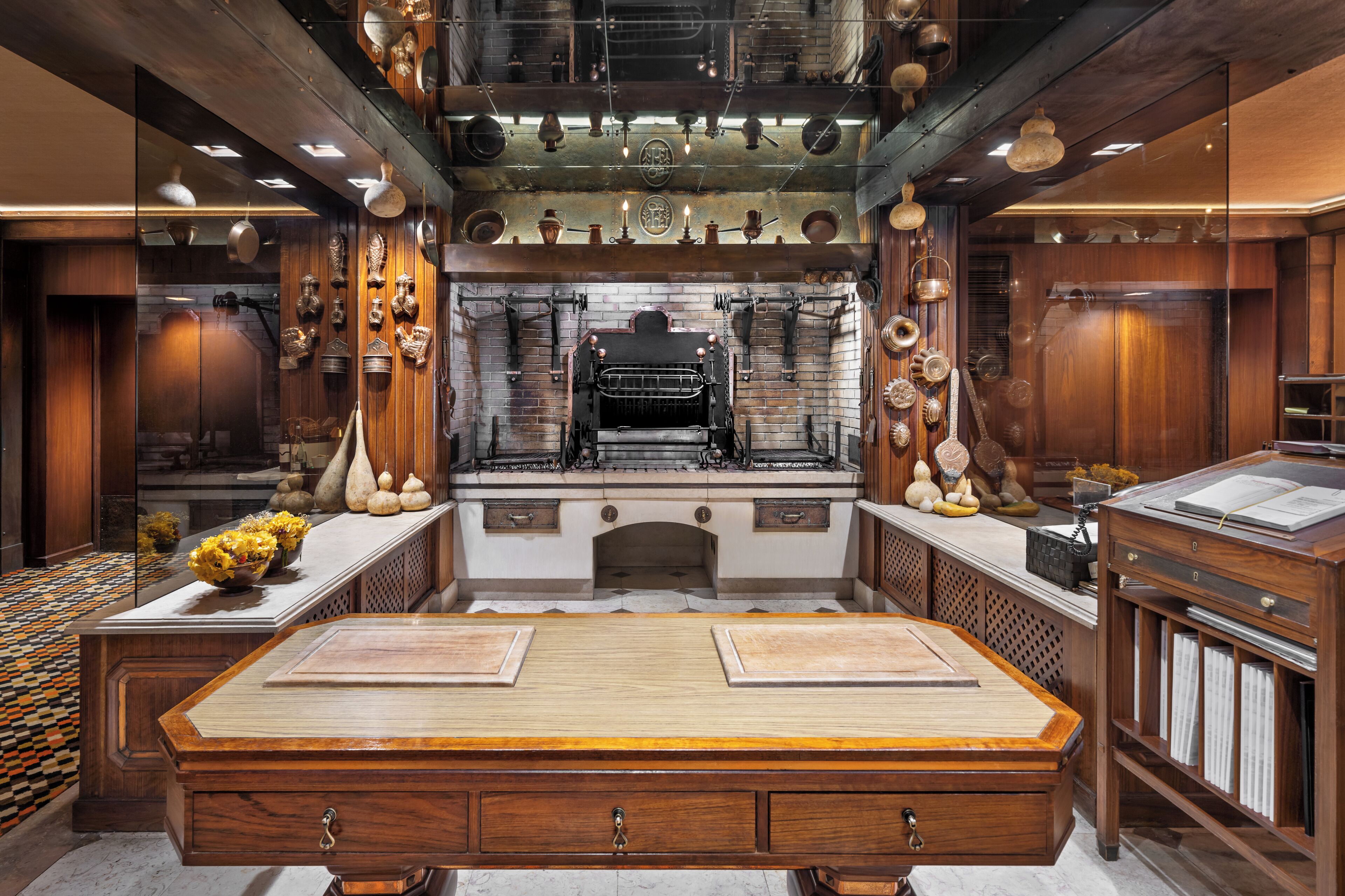 Une cuisine spacieuse avec une grande table en bois, des appareils électroménagers modernes et des objets décoratifs accrochés aux murs.