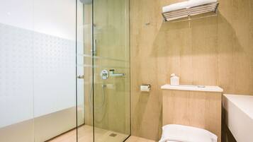 Un baño moderno con cabina de ducha de vidrio, un inodoro y un perchero para toallas.