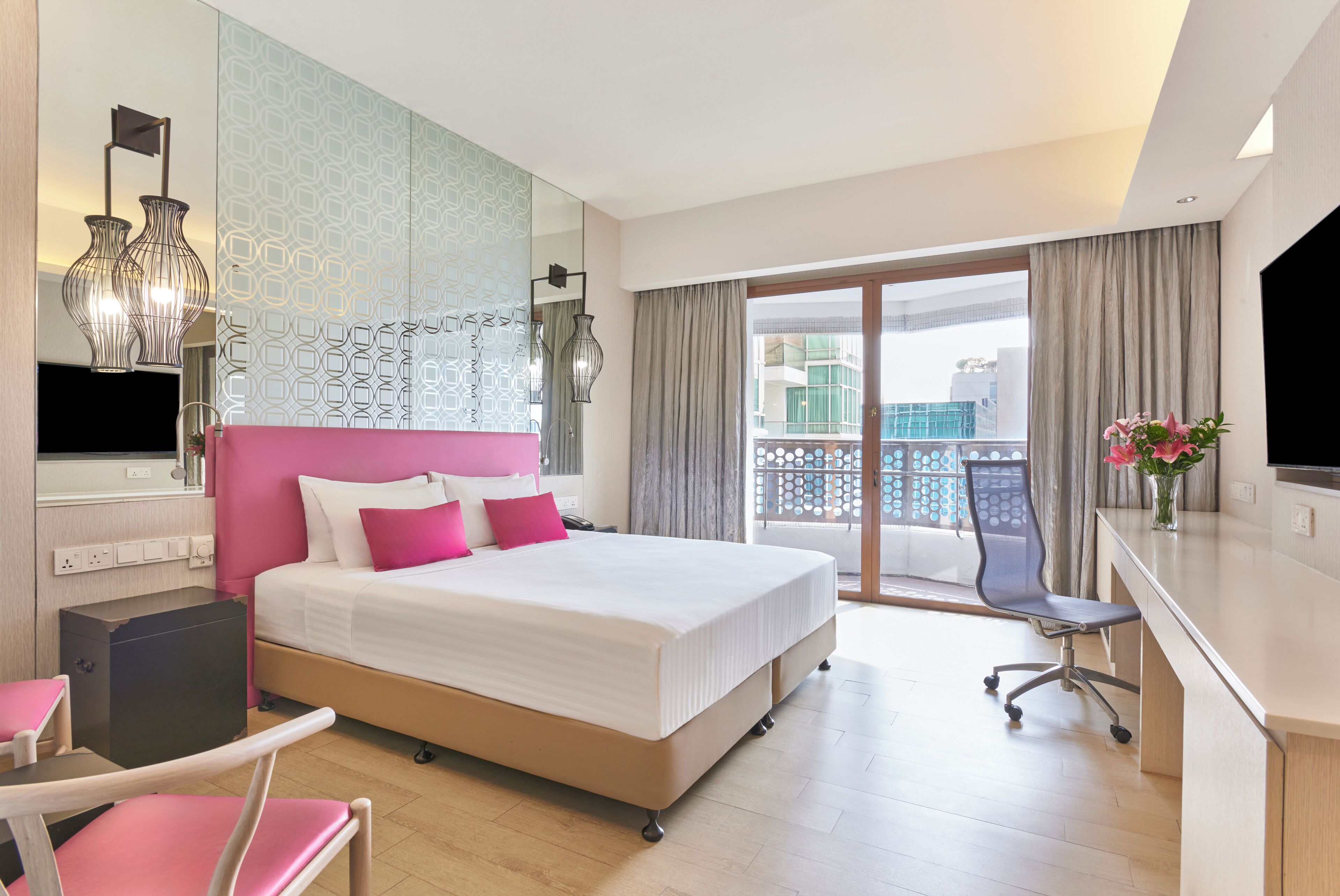 Habitación de hotel con cama, escritorio, silla y vista a la ciudad.