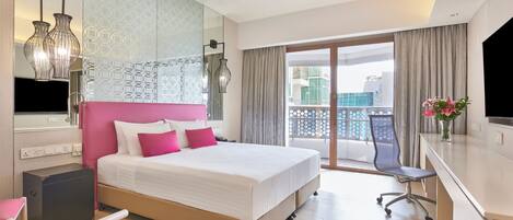 Habitación de hotel con cama, escritorio, silla y vista a la ciudad.