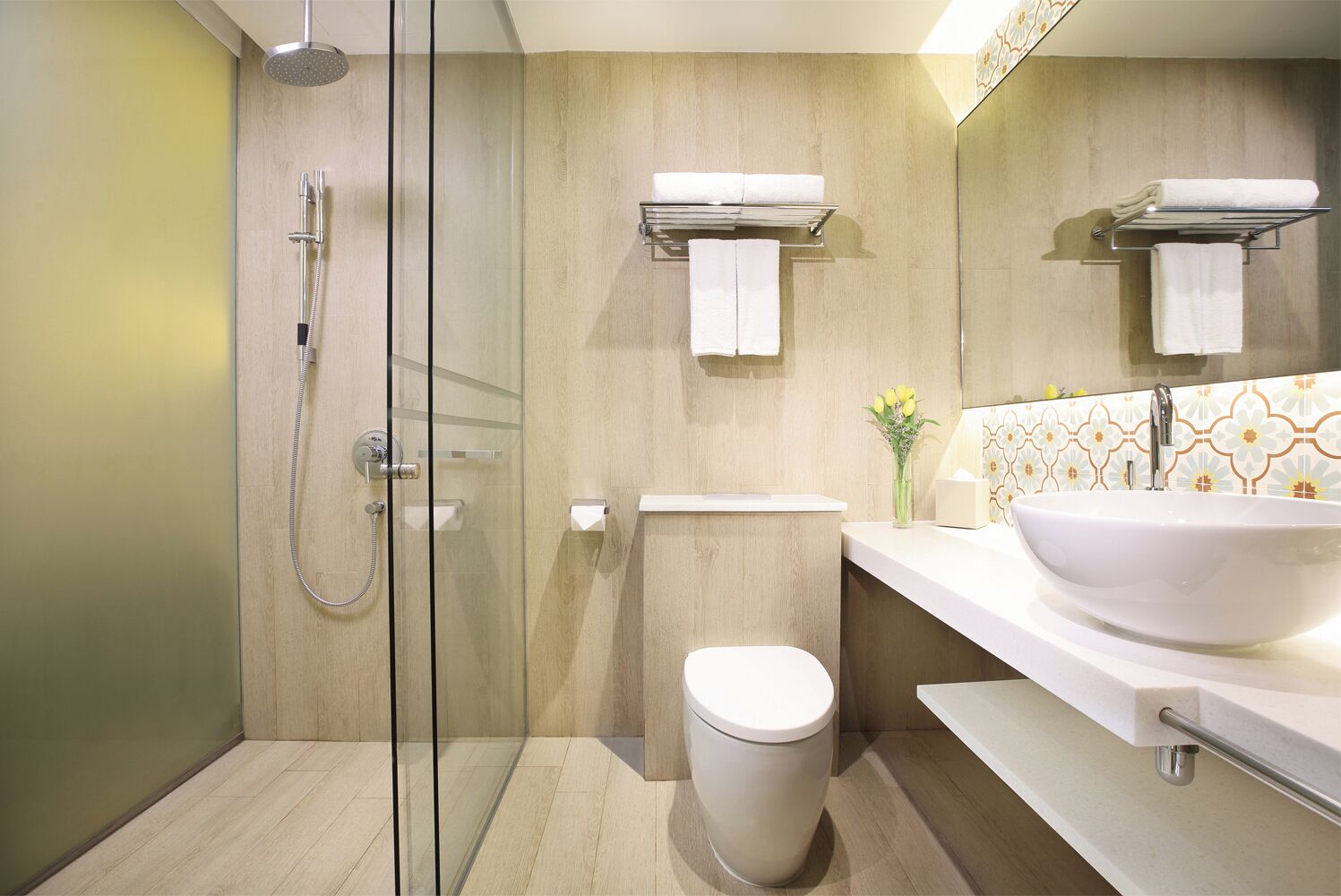 A modern bathroom with a glass-enclosed shower, a toilet, a sink, and a mirror.