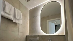 A modern bathroom with a white sink, toilet, and a towel rack. - Adrett Hotel Königsallee (Düsseldorf)
