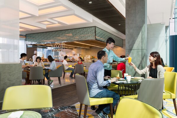 Un comedor moderno con sillas amarillas, una zona de cocina central y diversas opciones de asientos.