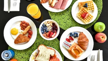 Una mesa con una variedad de platos y bebidas para el desayuno.