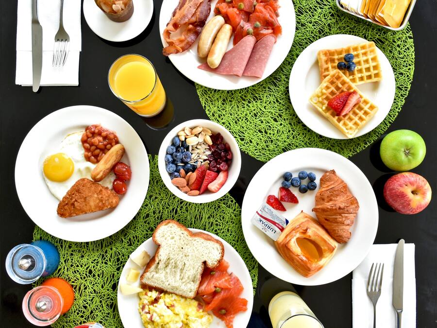 Una mesa con una variedad de platos y bebidas para el desayuno.
