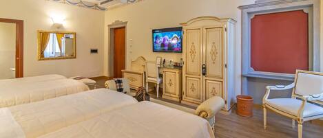 Habitación de hotel con dos camas, televisión, armario y una silla.