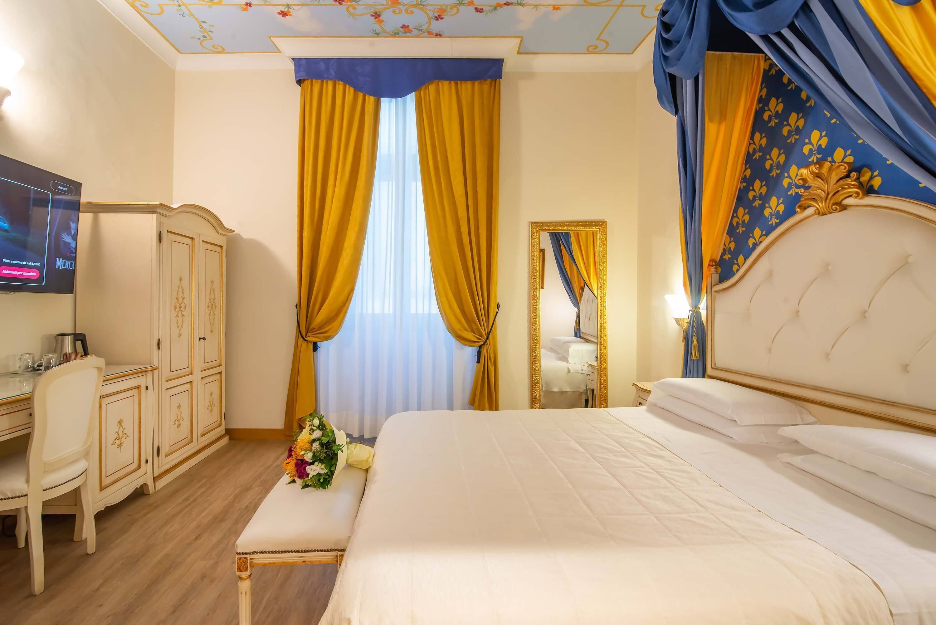 Une chambre d’hôtel avec un grand lit, un bureau avec une chaise, une armoire et un téléviseur.