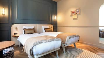 A modern hotel room with a large bed, bedside tables, and a view of the city through a window.