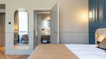 Ein Hotelzimmer mit Bett, einem Badezimmer mit Spiegel und einer Sitzecke mit Stühlen und Tisch.
