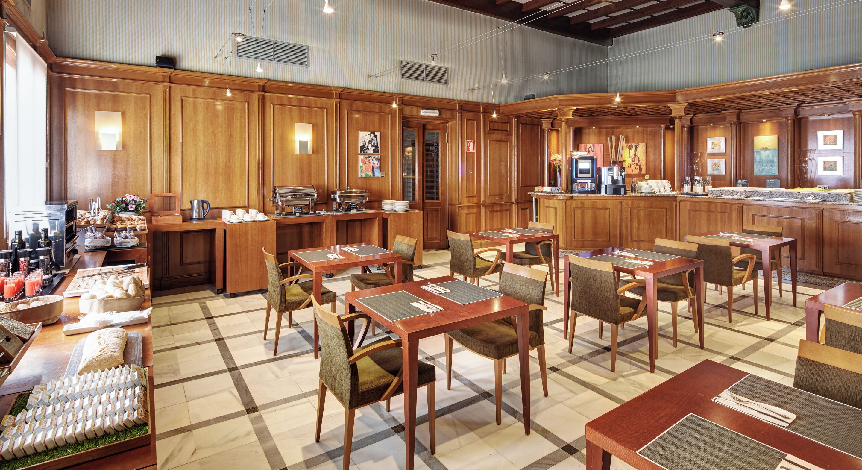 A restaurant with wooden decor, tables with cushioned chairs, and a buffet area with food and drinks.