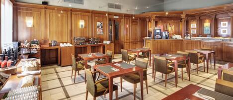 Un restaurante con decoración de madera, mesas con sillas acolchadas y una zona de bufé con comida y bebidas.