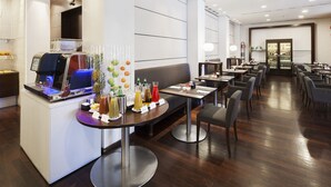 A modern hotel lobby with a self-service beverage station, seating areas, and a bar. - Hotel Igea (Brescia)