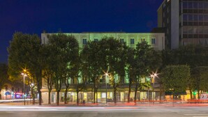 A modern hotel with a flat facade, multiple windows, and a well-lit entrance. - Hotel Igea (Brescia)