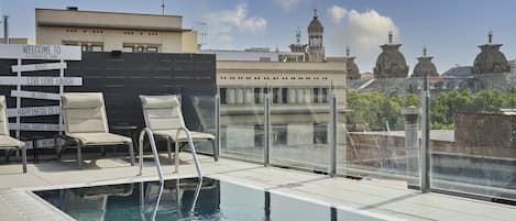 Una piscina al aire libre de temporada, tumbonas