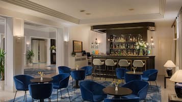 A bar area with blue chairs and a bar counter stocked with bottles.