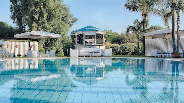 A swimming pool with a gazebo and outdoor seating area.