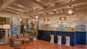 A lobby with a reception desk, seating area, and a large window.