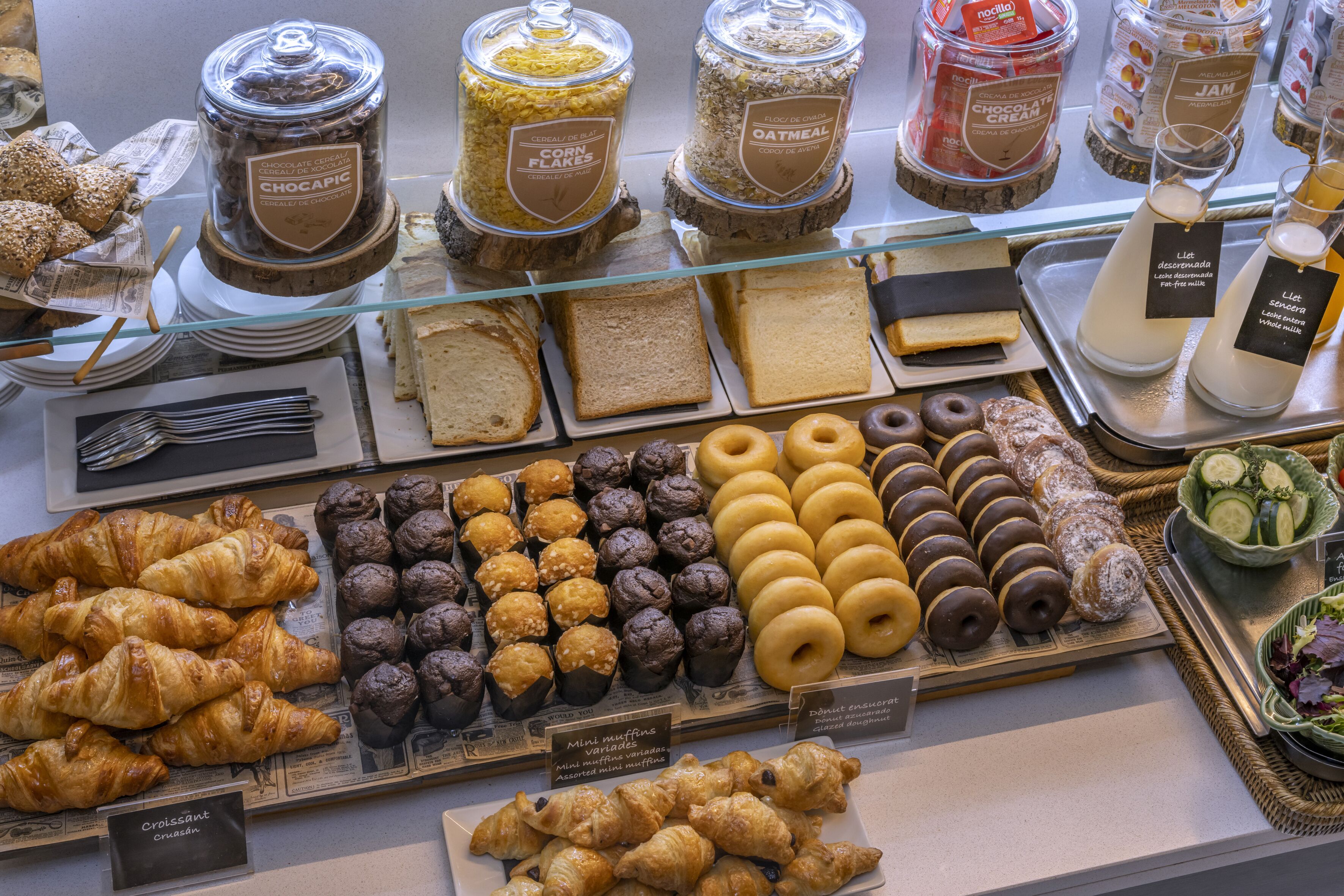 A bakery display with various baked goods like croissants, muffins, and donuts.