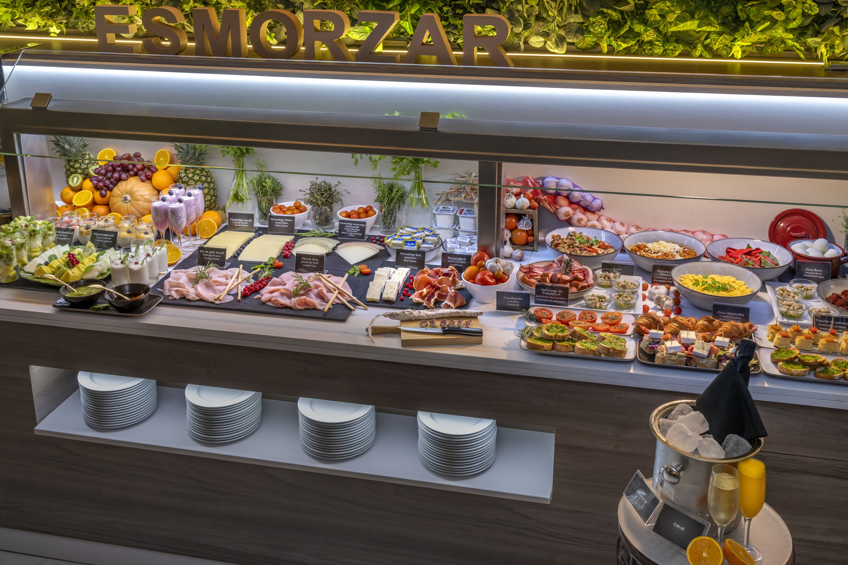 En buffet med forskellige spiser og et skilt, der står 'ESMORZAR'.