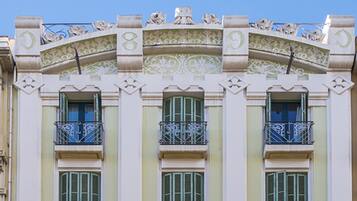 Un edificio con detalles arquitectónicos ornamentales, incluyendo diseños decorativos y balcones.