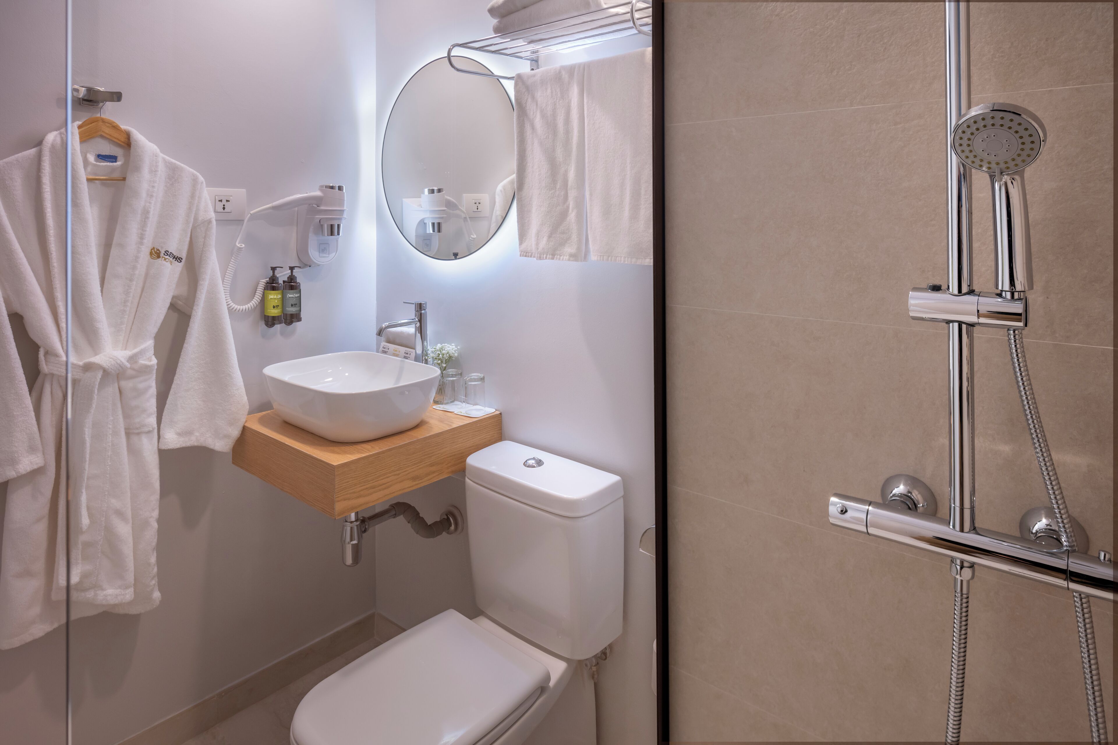 Ein Badezimmer mit Waschbecken, Toilette und Duschbereich inklusive Handbrause.