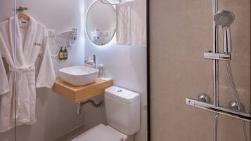 Ein Badezimmer mit Waschbecken, Toilette und Duschbereich inklusive Handbrause.