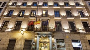 Eine Hotelfassade mit mehreren Balkonen, einer Flagge und einem Schild, das das Hotel kennzeichnet.