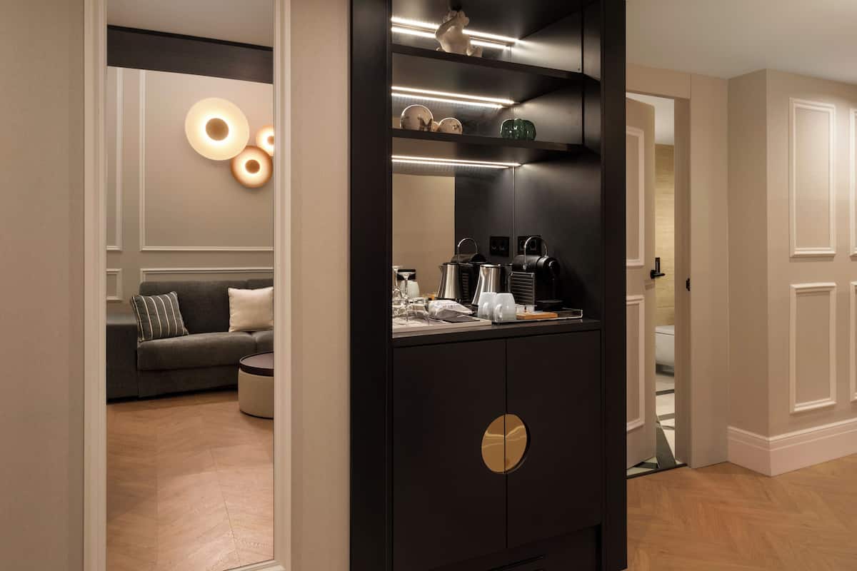 A modern kitchen with a black cabinet, a round gold handle, and a countertop with various kitchen items.