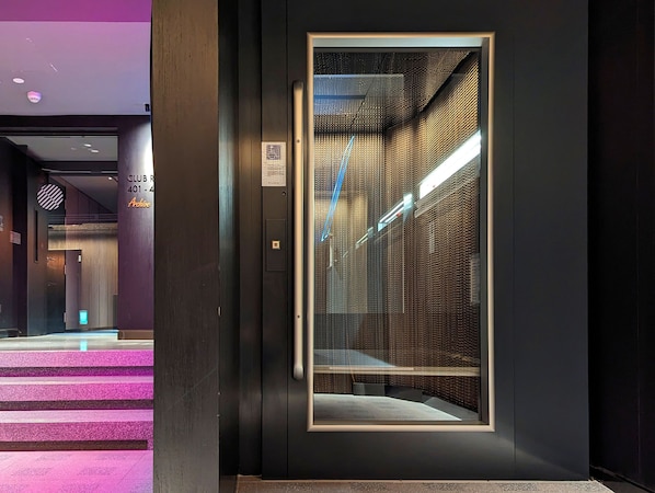 Een lift met een metalen inrichting en een glazen paneel.