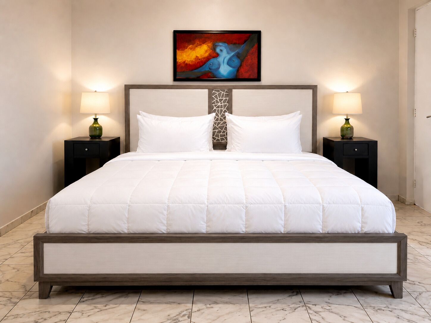 A large bed with a wooden frame, white bedding, and two bedside tables with lamps.