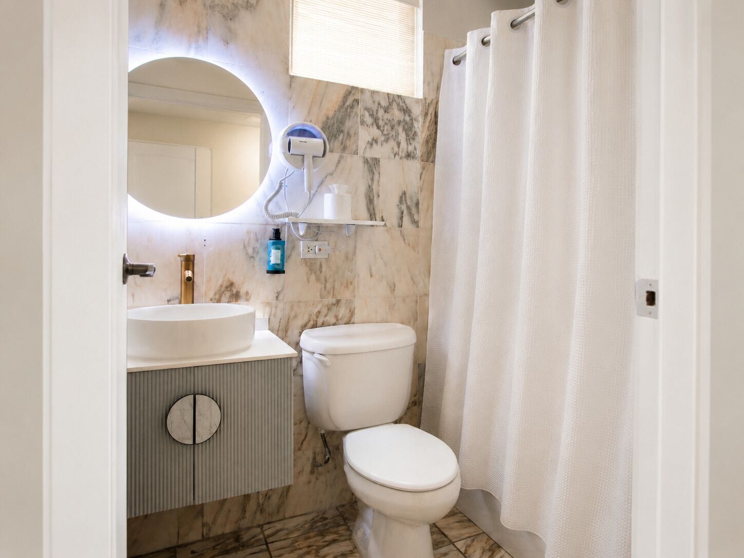 A bathroom with a white sink, toilet, and shower curtain.