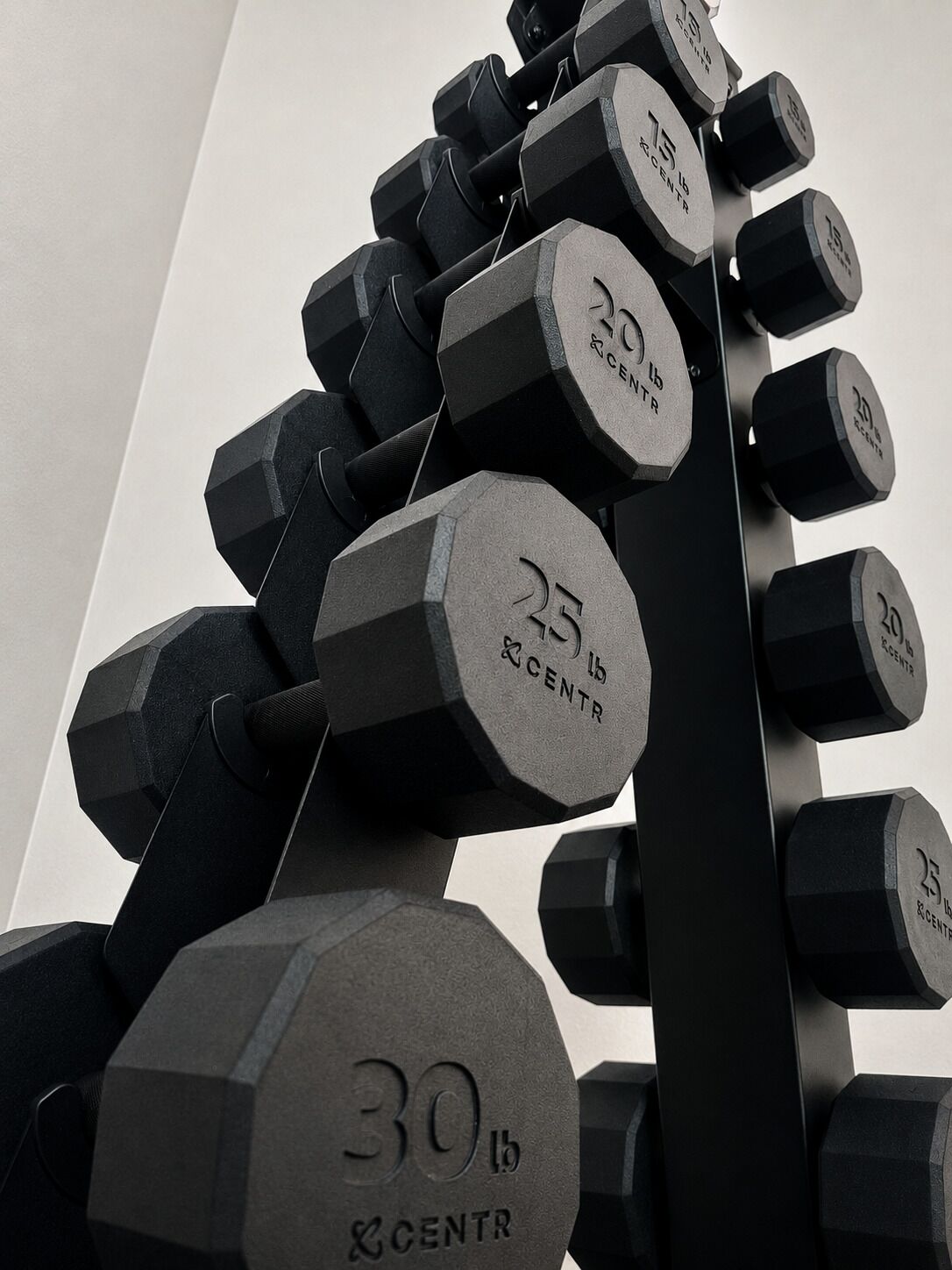 A set of hexagonal dumbbells with weight markings, arranged in a pyramid structure.