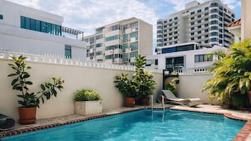 Una piscina al aire libre, tumbonas