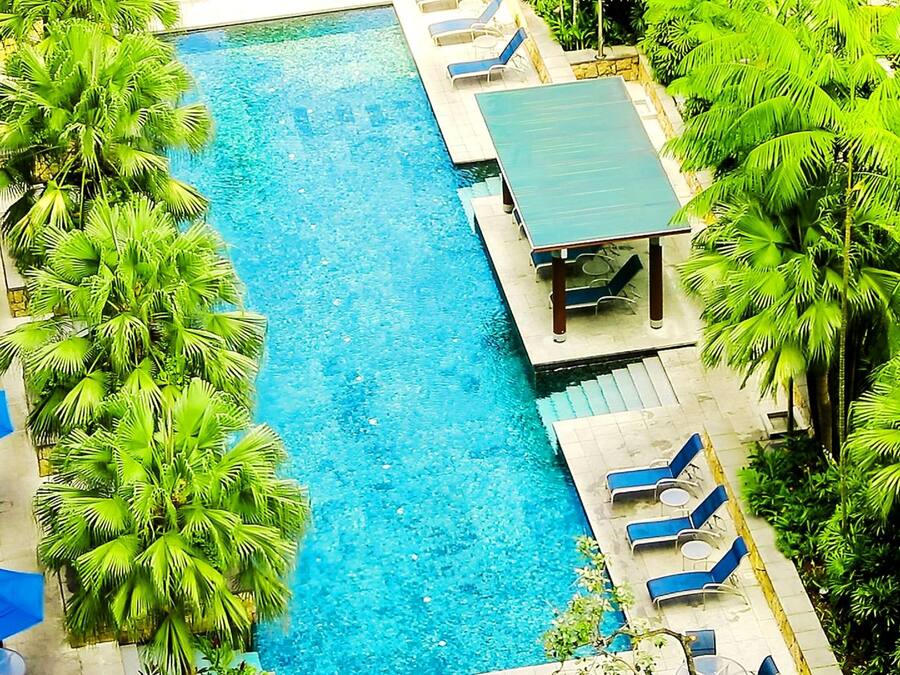 Una piscina al aire libre, camas de piscina gratis, sombrillas