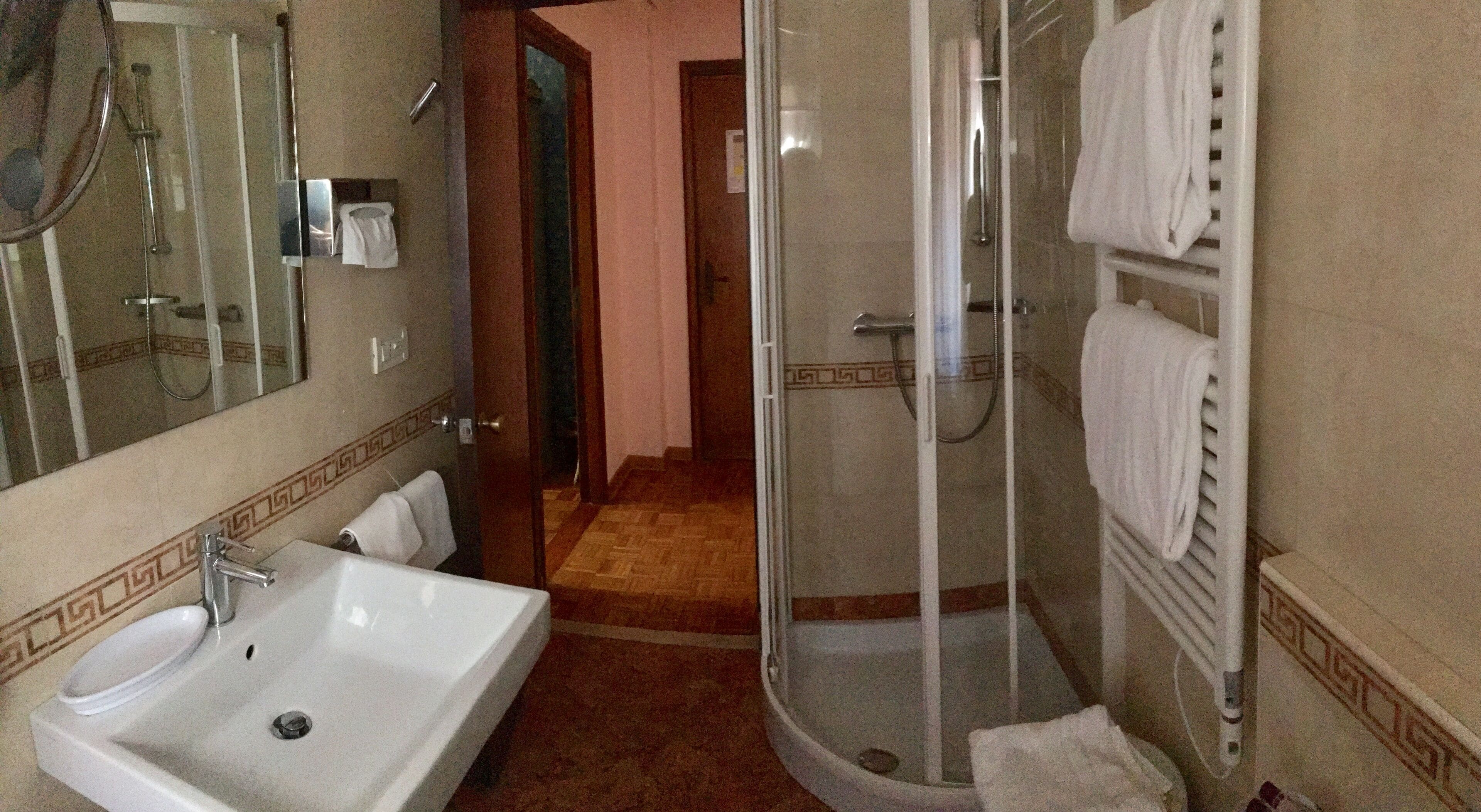 Une salle de bain avec un lavabo, un miroir et une douche.