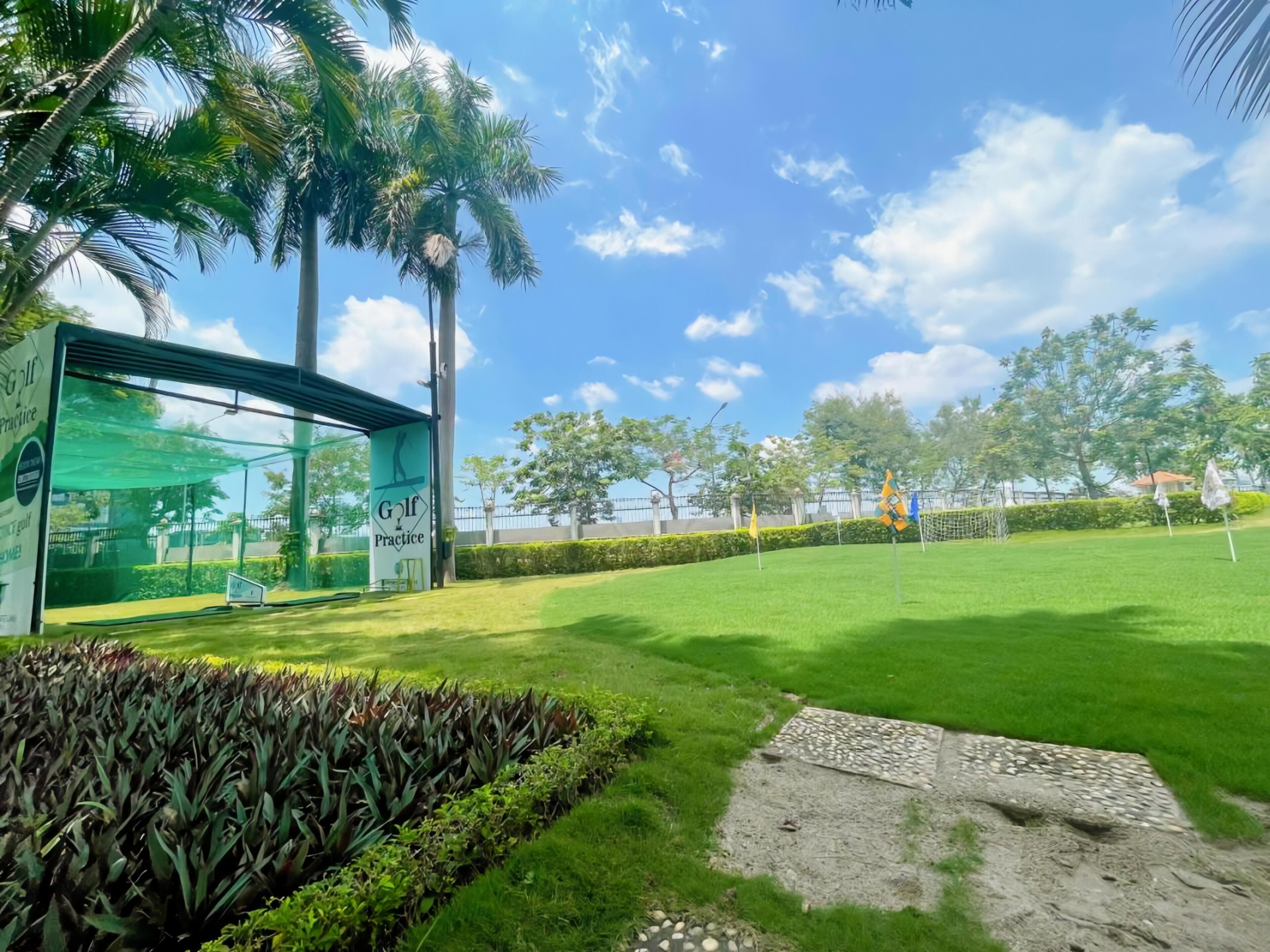 A golf practice area with a green field, palm trees, and a building labeled "Golf Practice".