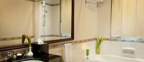 Un baño con un espejo grande, una bañera, un lavabo y una ducha.