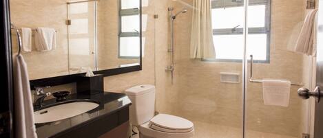 A modern bathroom with a glass shower enclosure, a toilet, and a sink with a vanity.