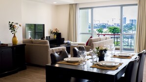Una sala de estar moderna con comedor, ventanas amplias y vista a la ciudad.