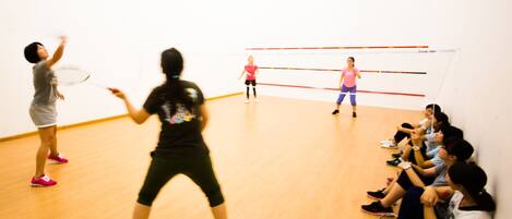 Ein Squashplatz mit Spielern und Zuschauern.