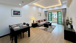 Una sala de estar moderna con comedor, sofá, mesa de centro y televisor.