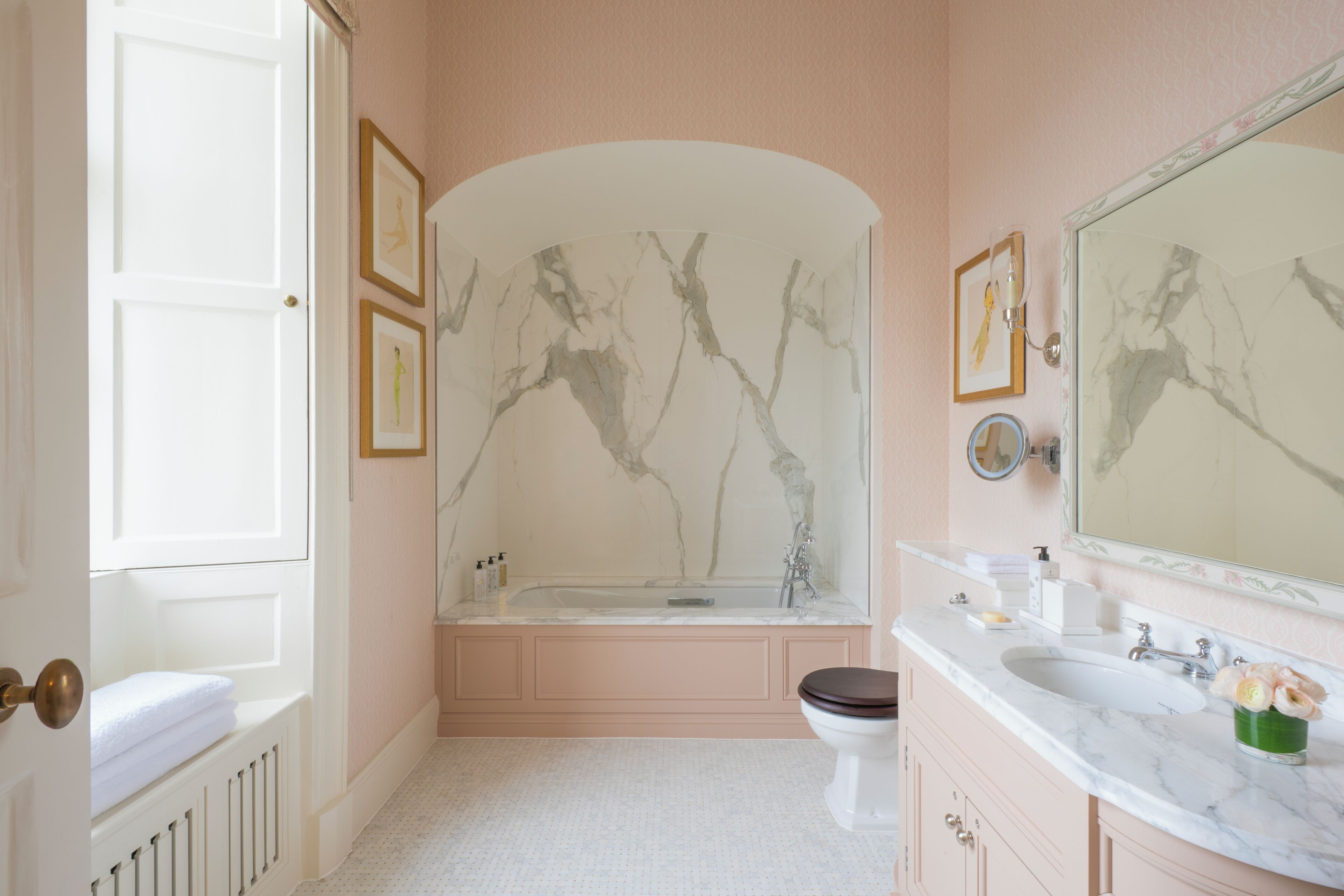 A bathroom with a bathtub, toilet, and vanity with a mirror.