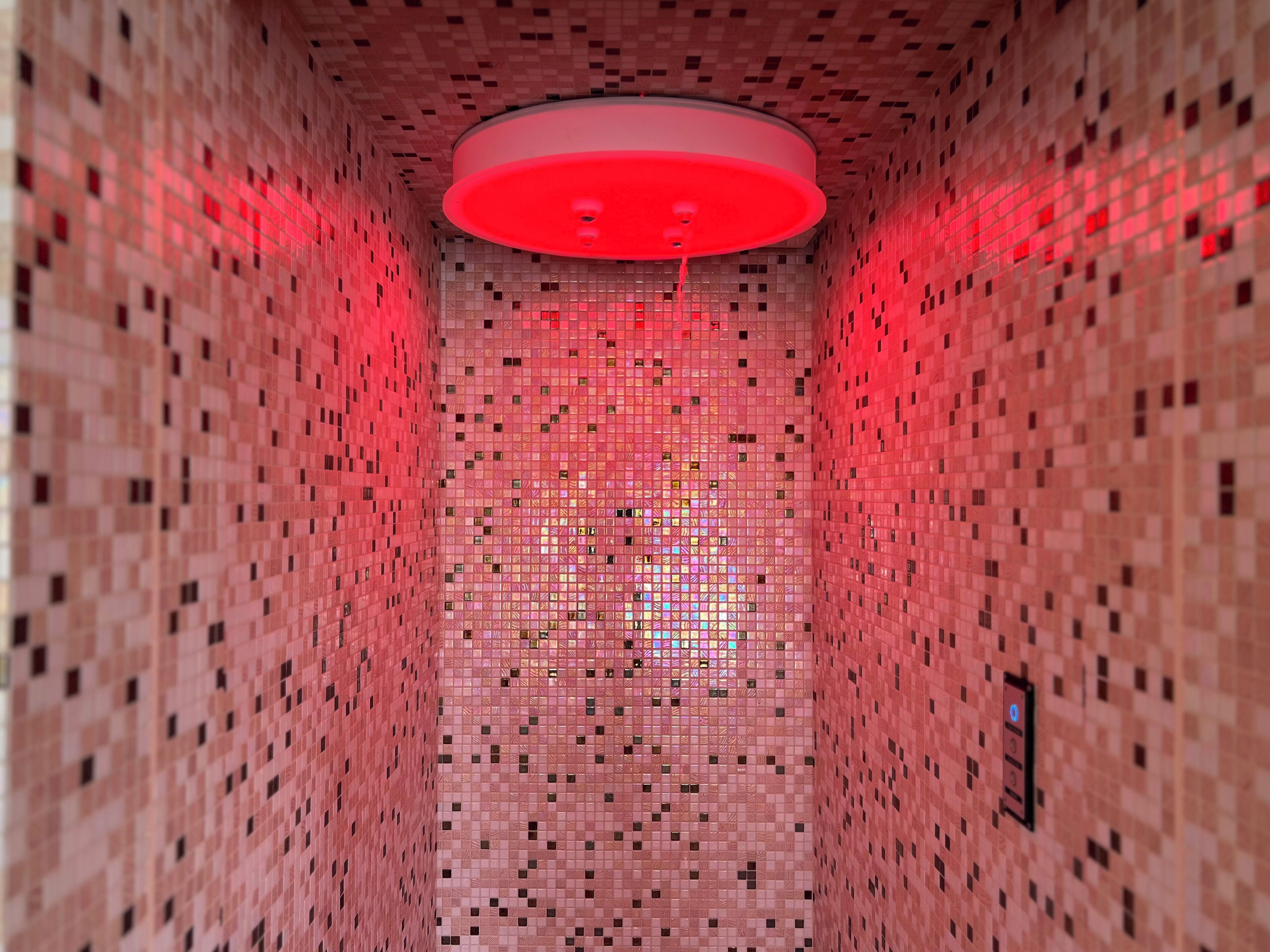 A narrow, tiled corridor with a red ceiling and a patterned wall.